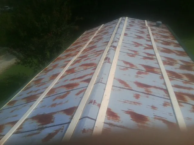 Rusted metal roof panels with new wood purlins before replacement — Storm Damage Roof Repair in Gallion by Roofing Brothers
