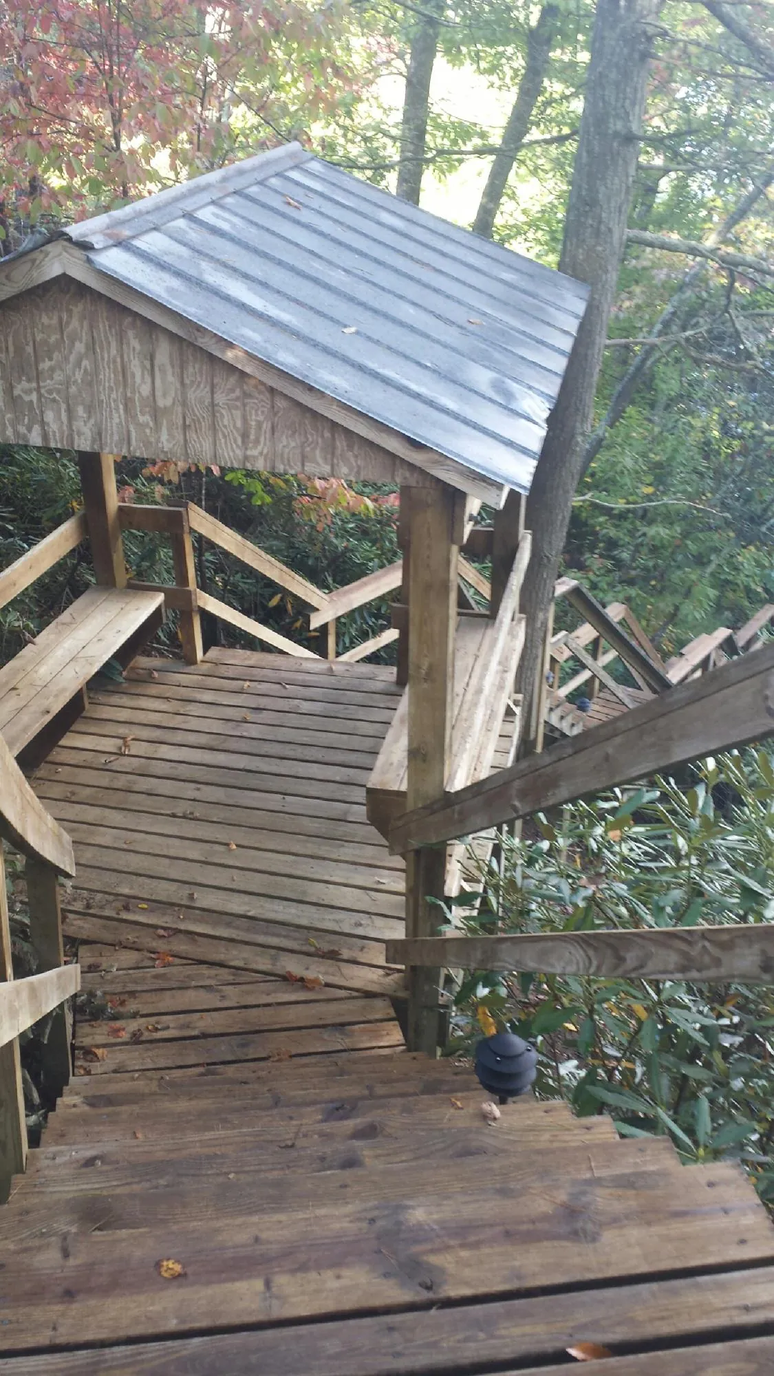 Metal roofed shelter over wooden steps on a wooded walkway — Skylight Repair & Installation work by our crew in Gallion