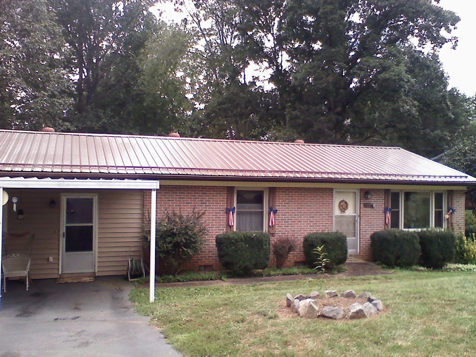 Bronze metal roof and carport on a brick ranch home — Roof Repair work by our crew in Gallion