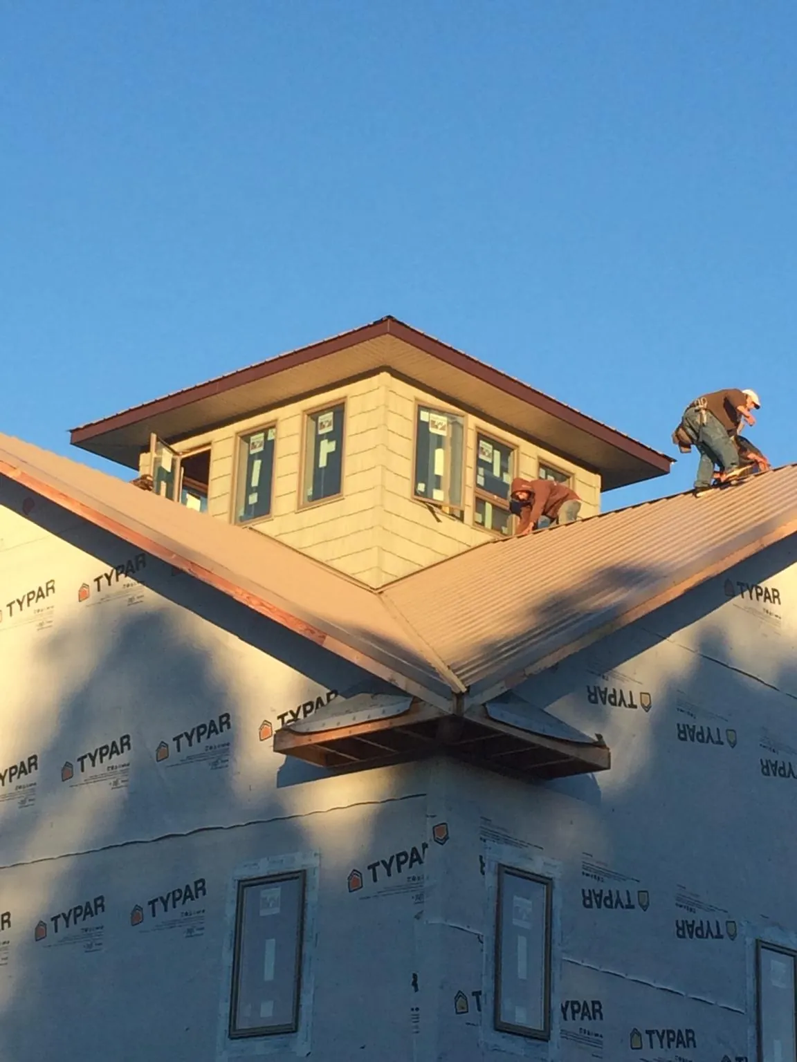 Roofers working around a rooftop cupola on a new metal roof at sunset — Roof Waterproofing in Gallion by Roofing Brothers